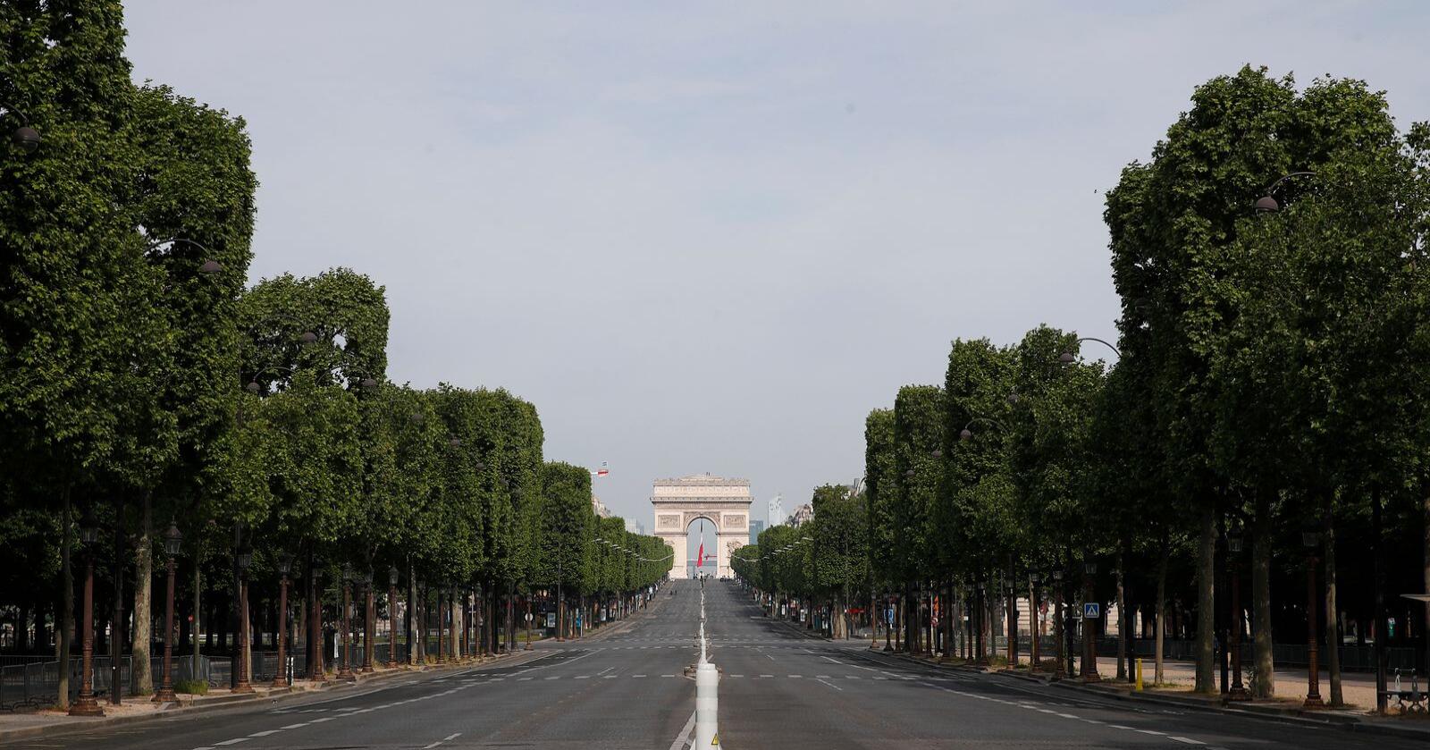En folketom Champs-Élysées i sentrum av Paris på frigjøringsdagen 8. mai. Veitrafikken er blitt kraftig redusert under koronakrisen, noe som har bidratt til store fall i CO2-utslippene. I Paris stupte utslippene med rundt 70 prosent i mars, ifølge BBC. Foto: François Mori / Pool / AP / NTB scanpix
