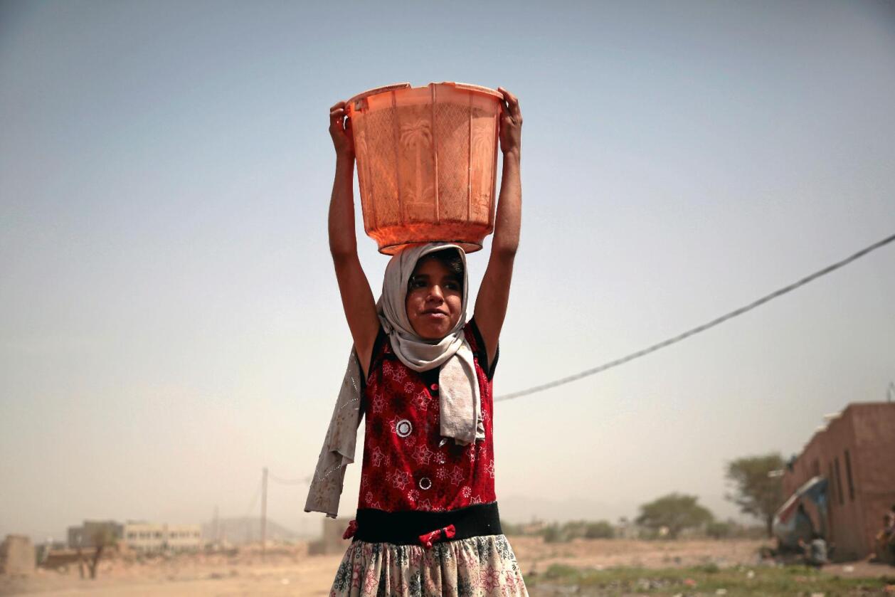 En jente bærer en bøtte med vann utenfor Sana i krigsherjede Jemen, som er hardt rammet av en koleraepidemi. Foto: Hani Mohammed / AP / NTB scanpix