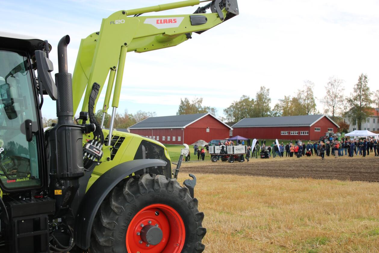AUTOMATISERING: De tradisjonelle traktorene vil i fremtiden overlate flere og flere oppgaver i jordbruket til roboter. I bakgrunnen demonstrerer den danske roboten ROBOTTI hvordan den jobber på et jorde.