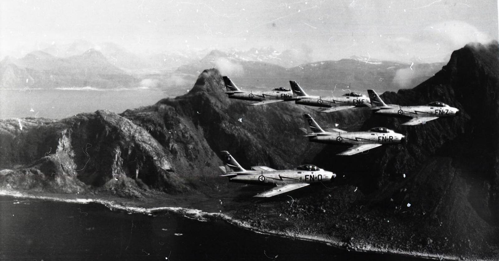 Fem F-86 Sabre fra 331-skvadronen flygende i formasjon i Nord-Norge rundt 1960.  Foto: Norsk Luftfartsmuseum