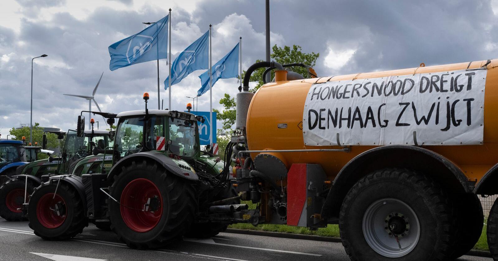 "Hungersnød truer, Haag hold kjeft" skriver bøndene på møkkasprederen. Foto: AP/Peter Dejong/NTB
