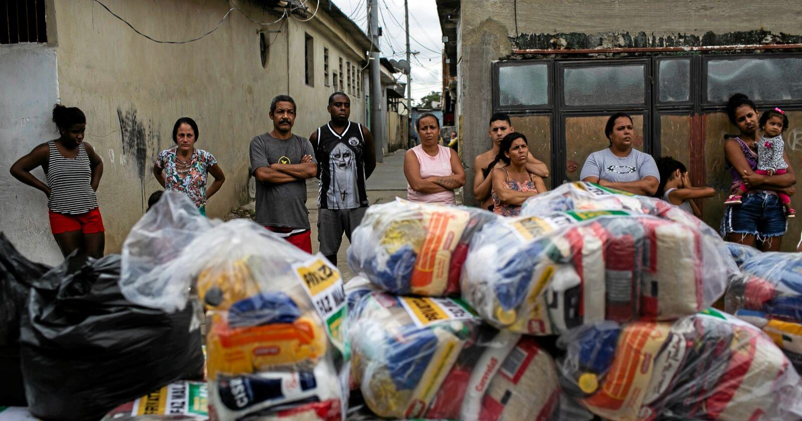 Innnbyggere i Vila Vintem i Rio de Janeiro i Brasil venter på å få utdelt mat. Koronaepidemien har ført til nedstenging, arbeidsledighet og mangel på penger til å kjøpe mat. Foto: Bruna Prado / AP / NTB